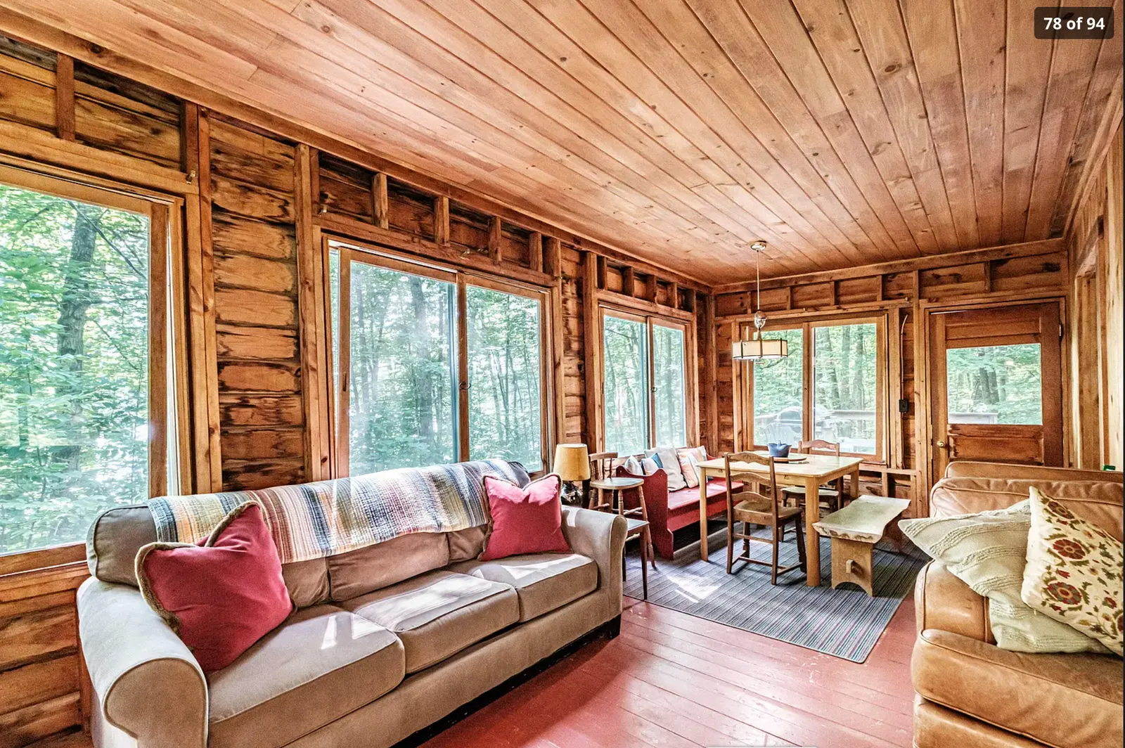Cozy cabin living room with fireplace and forest views