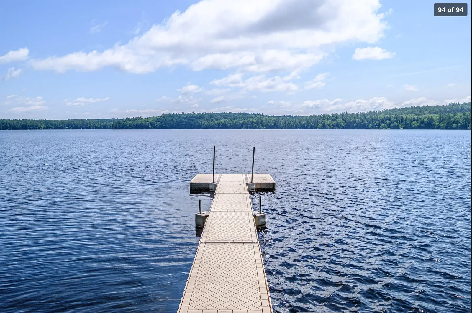 Private dock reaching into blue Keoka Lake