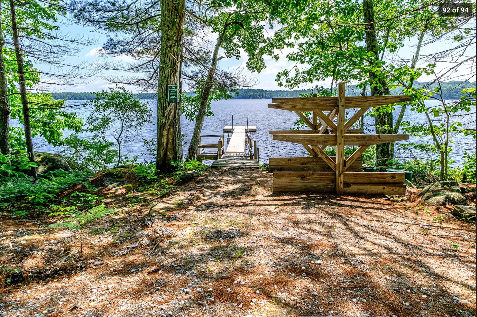 Wooden path and stairs descending through ferns toward the lake