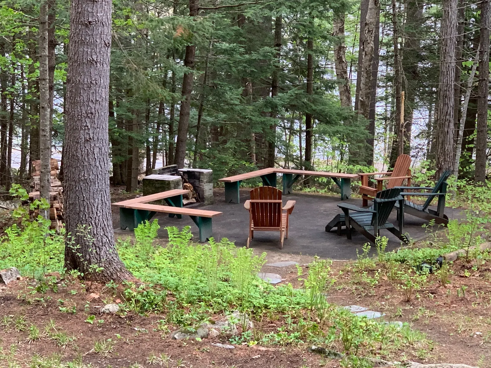 Campfire area with Adirondack chairs and simple wooden benches