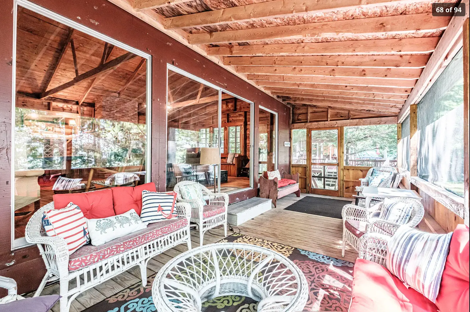 A bright screened porch with wicker seating