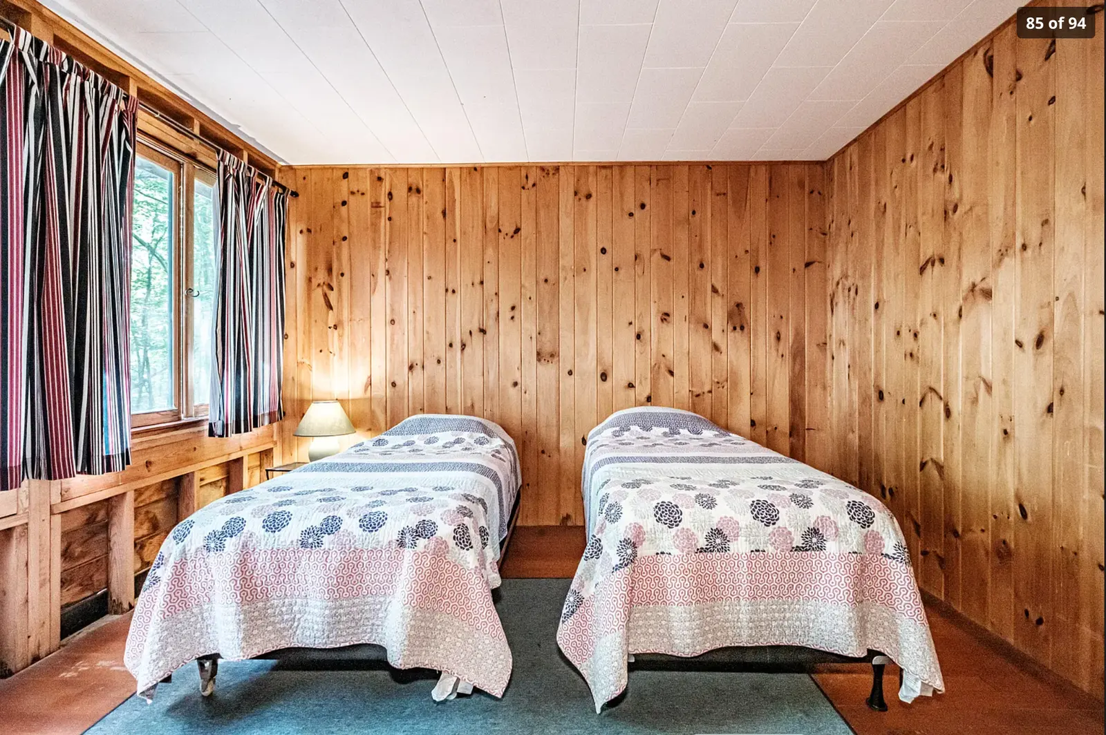 Pine-paneled bedroom with two twin beds