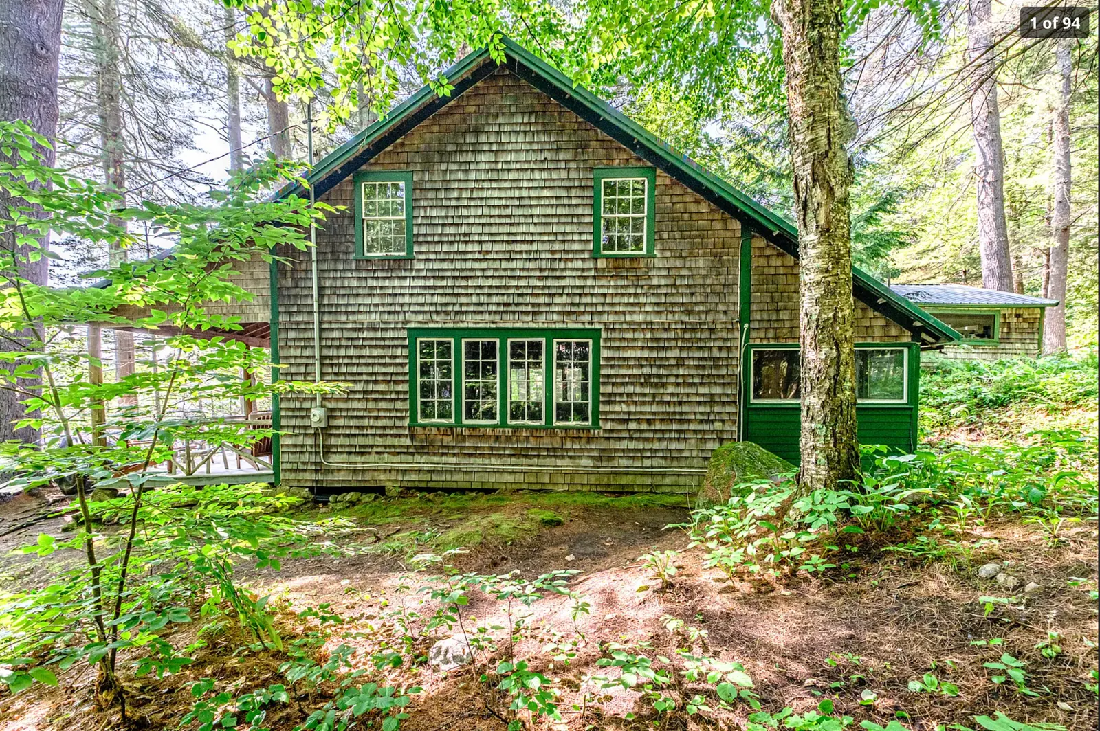 The historic shingled main cabin among tall trees